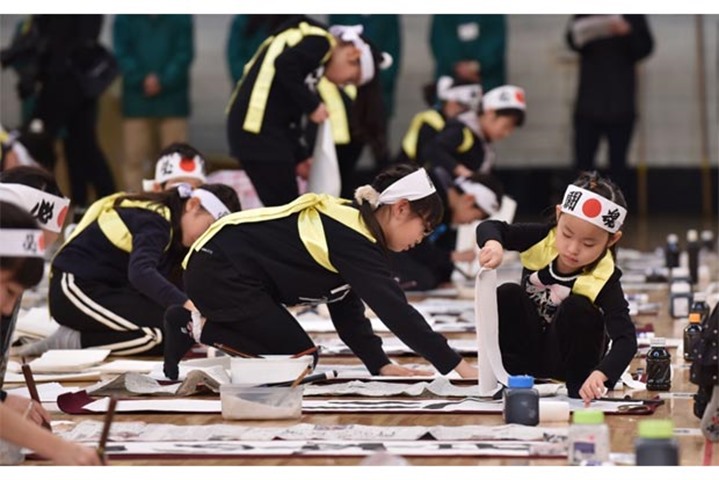 Young contestants write calligraphy during the annual event in Tokyo