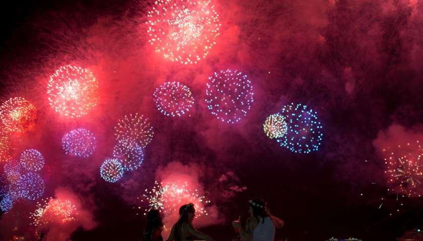 People watch as fireworks explode over Copacabana beach during New Year celebrations in Rio de Janei