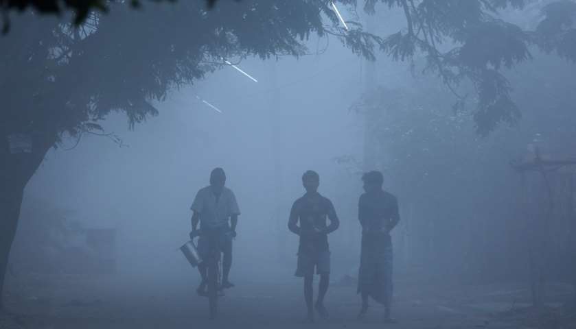 People walk through heavy fog in Chennai, India