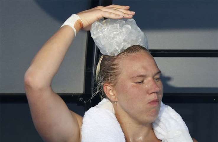 Kaia Kanepi of Estonia rests with an ice pack on her head during a break in her match