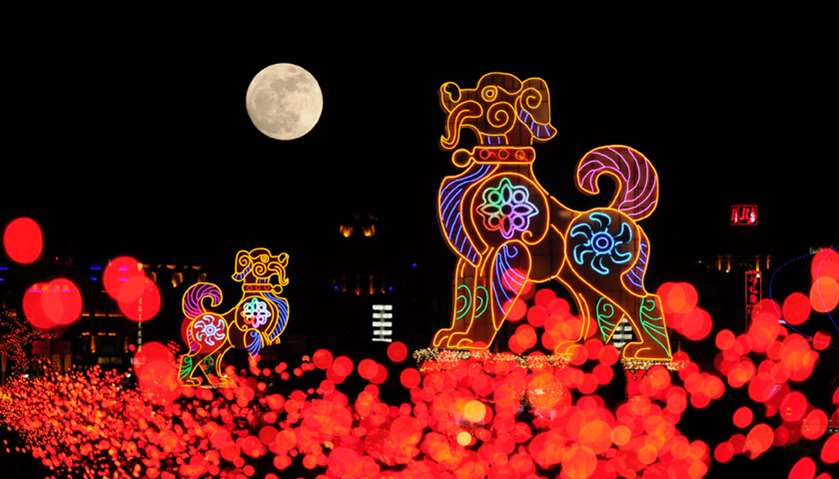 The supermoon is seen behind dog-shaped giant lanterns in Dalian, China