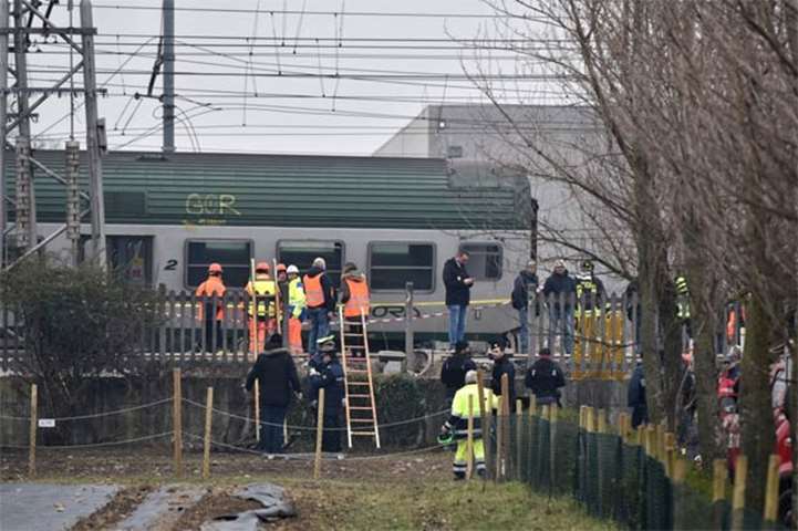 Italian rescuers and policemen work on the site of a train derailment near Milan on Thursday
