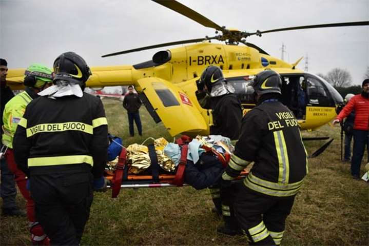 Italian rescuers evacuate a victim by helicopter on the site of a train derailment near Milan