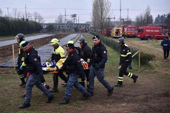 Rescuers and policemen carry a victim on a stretcher following a train derailment