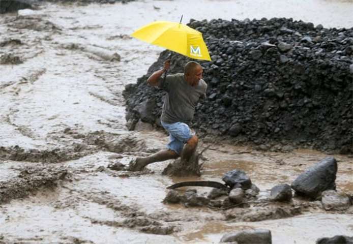 A resident wades through a river with lahar flow in Albay province on Saturday