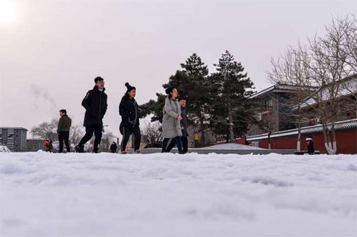 Chinese people walk on the snow-covered ground at the Imperial Palace in Shenyang