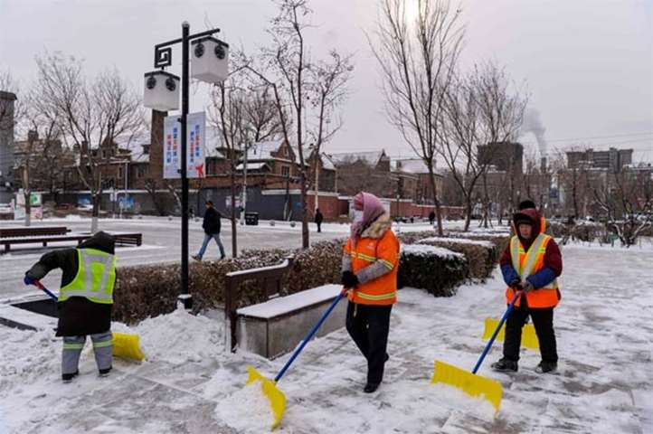 Chinese workers remove snow near the Imperial Palace in Shenyang on Monday