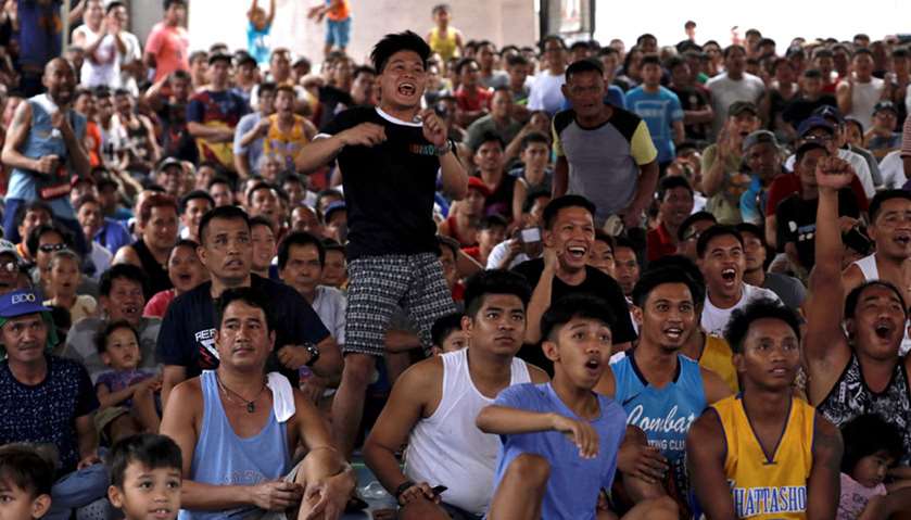 Fans of Philippine boxing champion Manny Pacquiao cheer as they watch the WBA welterweight world tit