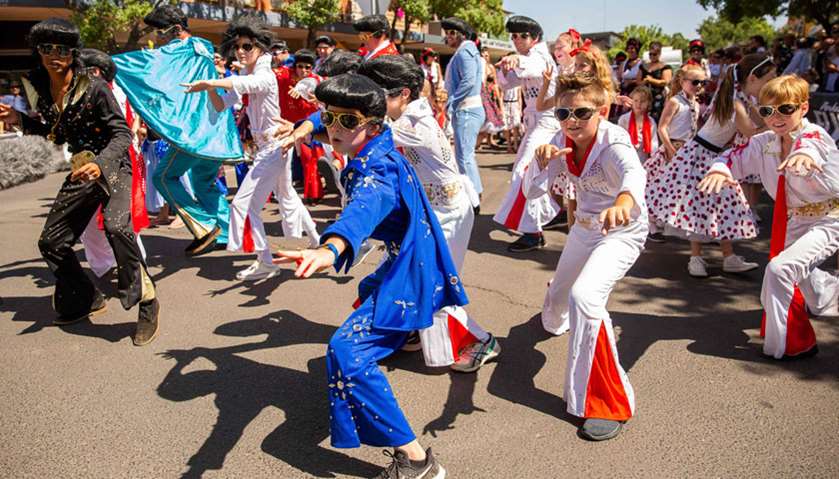 Children dressed as Elvis dancing in the street during the 2019 Parkes Elvis Festival in Parkes