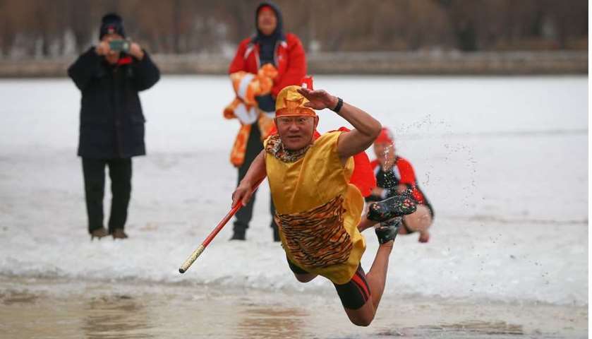 A winter swimming enthusiast jumps into a partly frozen lake in Shenyang, Liaoning province, China