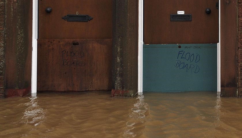 Flood boards in place to protect the front doors of two properties.