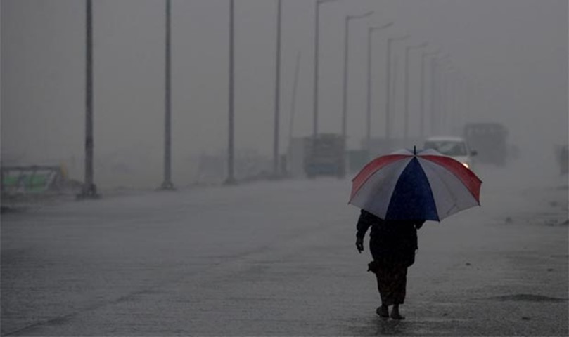 A woman walks on the road during heavy rains in Chennai on Thursday