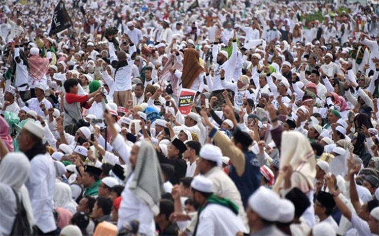 Indonesian Muslims gather in the rain at Jakarta\'s National Monument Park as part of a rally