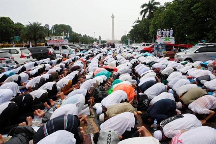 Indonesian Muslims attend Friday prayers during a rally calling for the arrest of Jakarta\'s governor