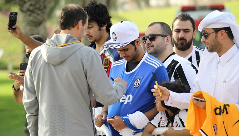 Juventus coach Massimiliano Allegri signs autographs for fans after a training session