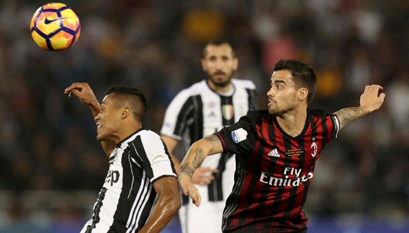 Juventus\' Alex Sandro fights for the ball with AC Milan\'s Fernandez Suso.
