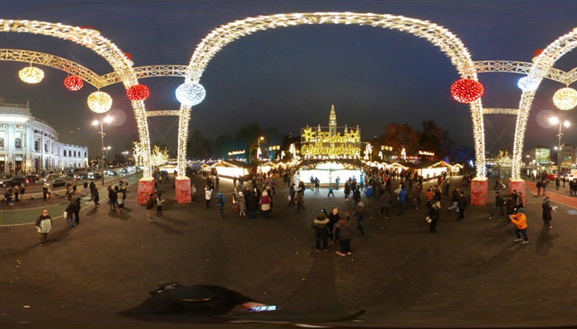 An archway of lights leads to the entrance of the Christmas market in Vienna, Austria