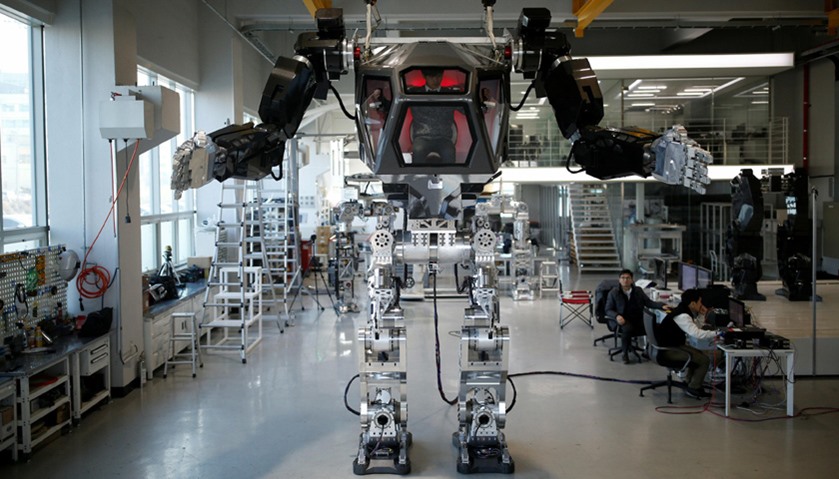 An employee controls the arms of a manned biped walking robot \"METHOD-2\" during a demonstration