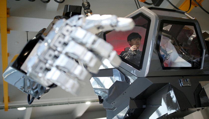 An employee controls the arms of a manned biped walking robot \"METHOD-2\" during a demonstration