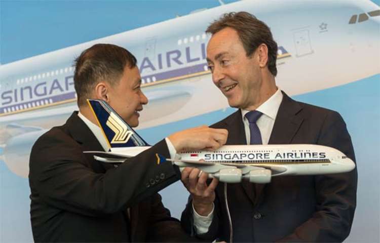 Singapore Airlines CEO Goh Choon Phong presents a SIA plane model to Airbus\' Fabrice Bregier