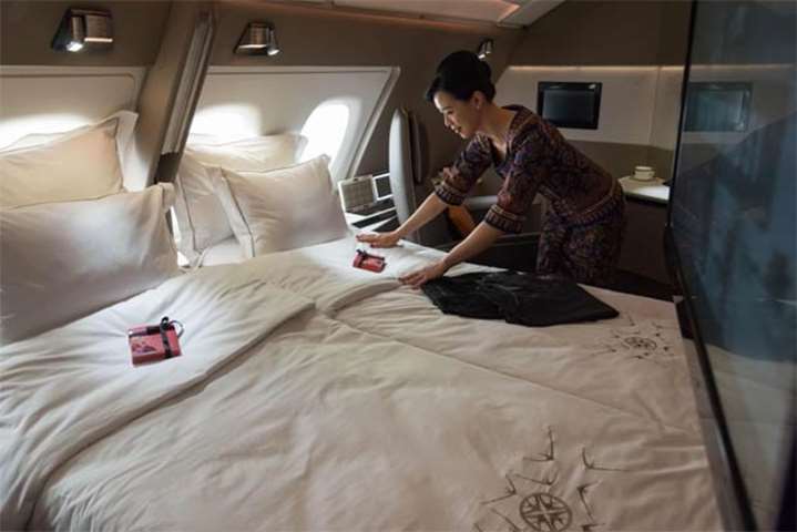 An air stewardess arranges bedsheets of a double bed in a suite of Singapore Airlines\' new A380
