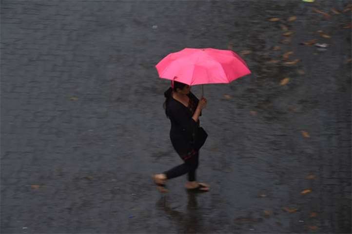 A commuter rushes across a street in Mumbai as Cyclone Ockhi moved up India\'s west coast
