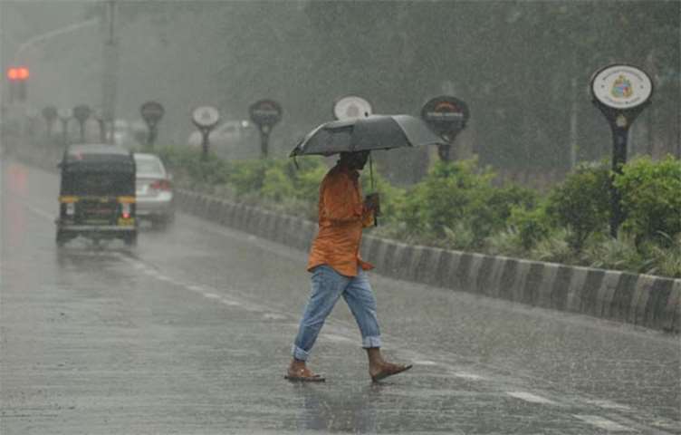 An Indian man crosses a street during heavy rain in Mumbai on Tuesday