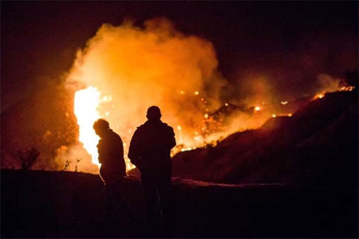Spectators watch as the Creek Fire burns near homes in a Los Angeles neighbourhood