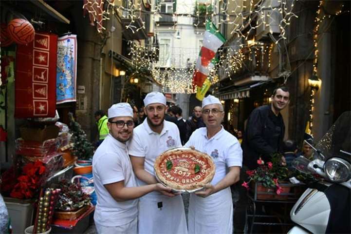 Pizza makers express their joy over the Unesco decision, outside the Pizzeria Brandi in Naples