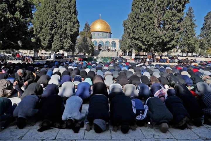 Palestinians pray in front of the Dome of the Rock mosque in Jerusalem\'s Old City on Friday