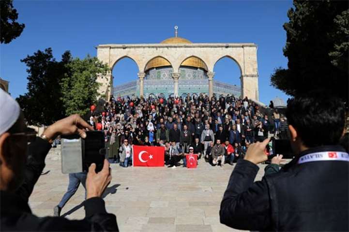 Turkish tourists pose for a group photo ahead of Friday prayers in Jerusalem\'s Old City