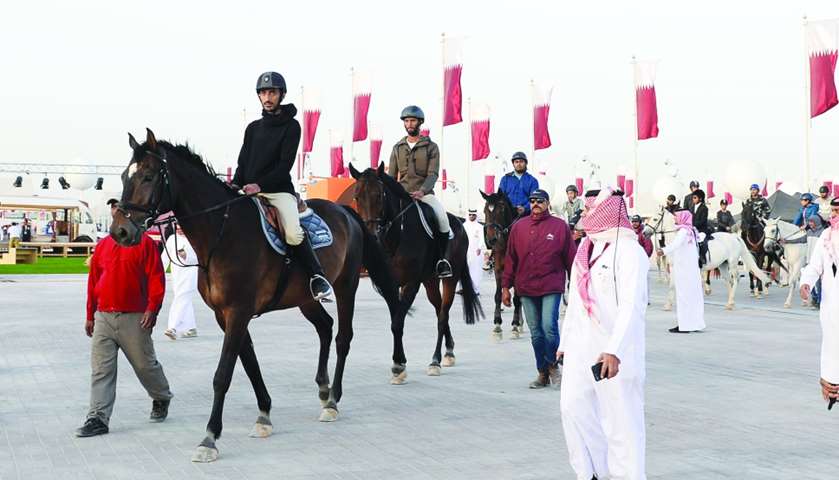 Horse riders move through Darb Al Saai