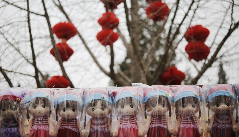 Dolls are offered for sale under a decorated tree as the Chinese Lunar New Year is celebrated