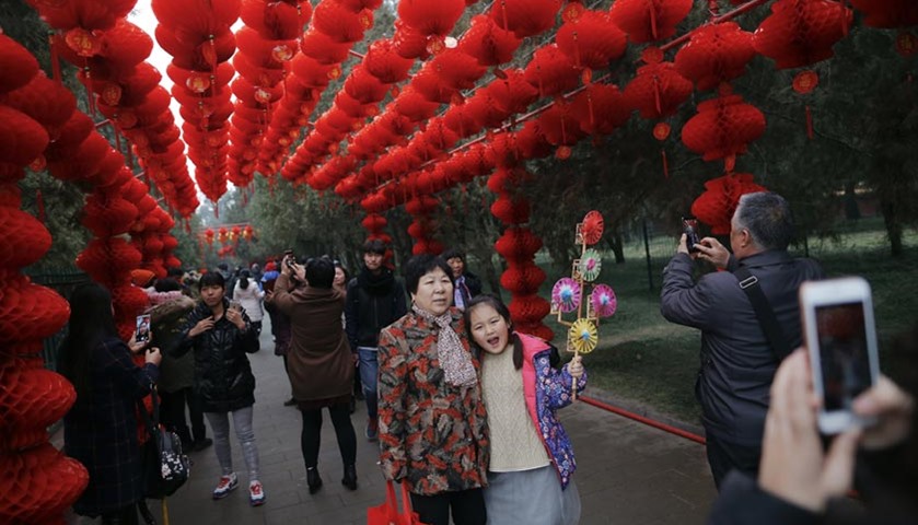 People have their pictures taken under red lanterns in Beijing