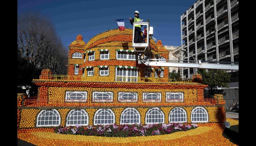 A worker puts the final touch to a sculpture made with lemons and oranges at the Lemon festival