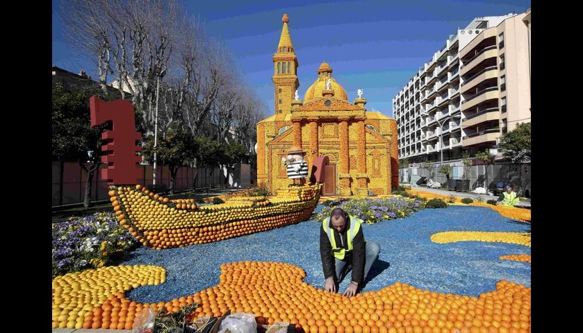 Workers put the final touch to a replica of a gondola and a Venetian palace made with lemons and ora