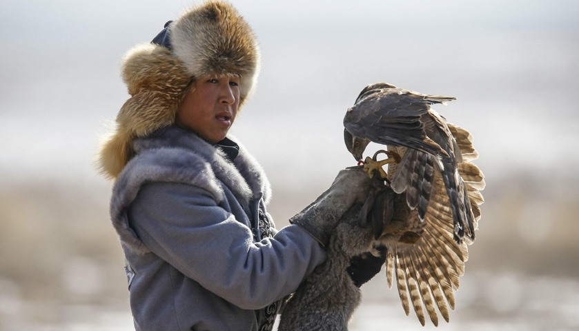 A hunter holds a rabbit caught by his tamed hawk during the traditional hunting contest