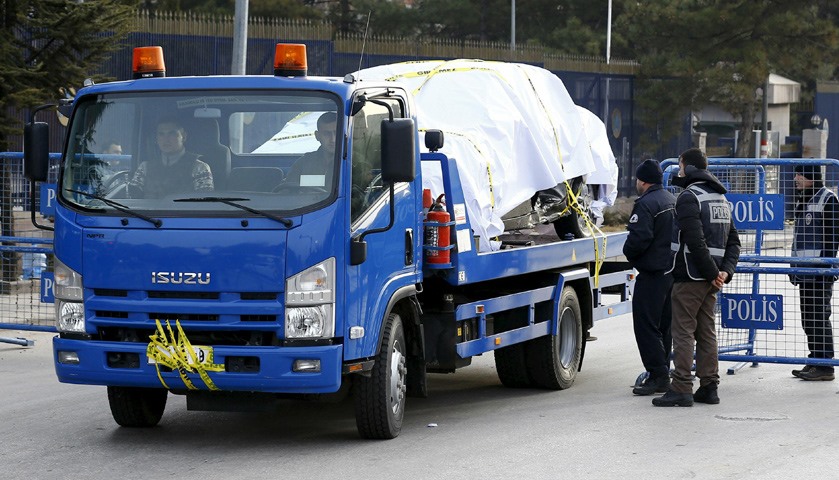 A car which was damaged in the explosion is removed from the area