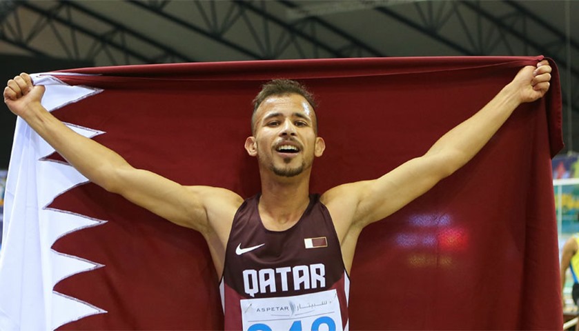 Qatar\'s Mohamad Algarni waves the national flag after winning the 1500m event