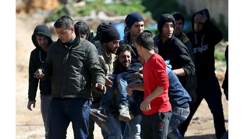 A wounded Palestinian is evacuated during clashes with Israeli troops