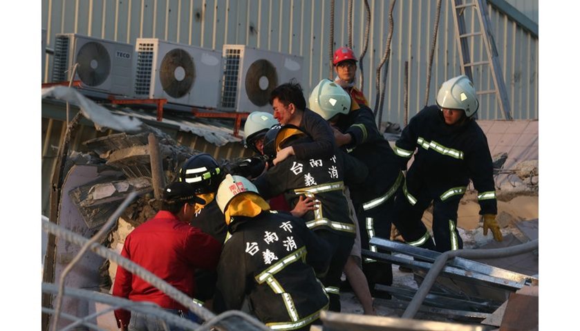 Rescue personnel carry a survivor at the site of a collapsed building in the southern Taiwanese city