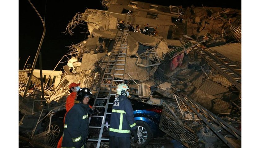 Rescue personnel search through debris at the site of a collapsed building in the southern Taiwanese