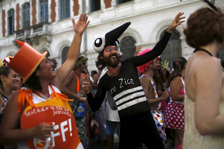 Revellers wearing a costume representing the Aedes aegypti mosquito (right) and an insect repellent.