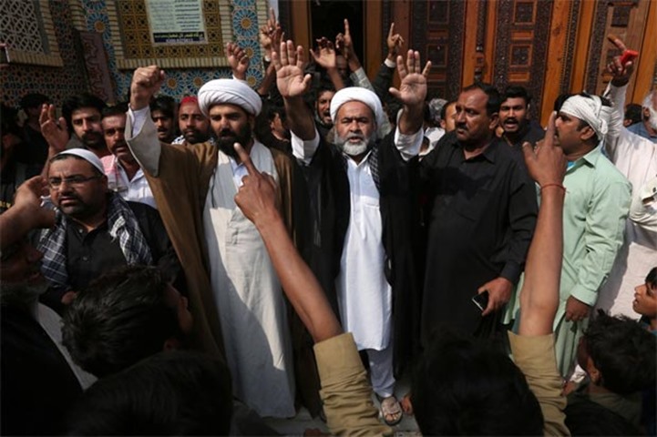 Men and local religious leaders chant slogans as they protest to condemn Thursday\'s suicide blast