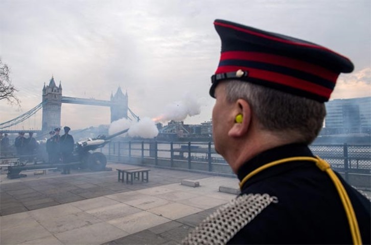 The Tower Bridge is seen in the background as a royal gun salute is fired outside Tower of London