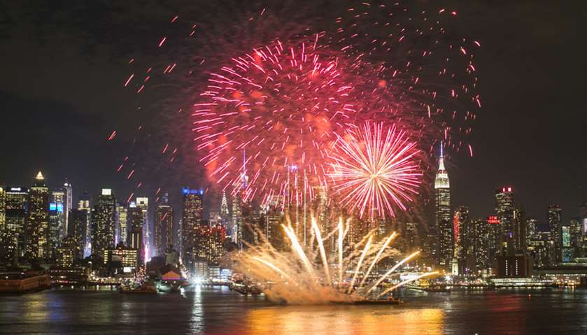 Fireworks explode over the Hudson River against the backdrop of midtown Manhattan