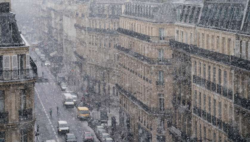 People walk on the street as snow falls in Paris