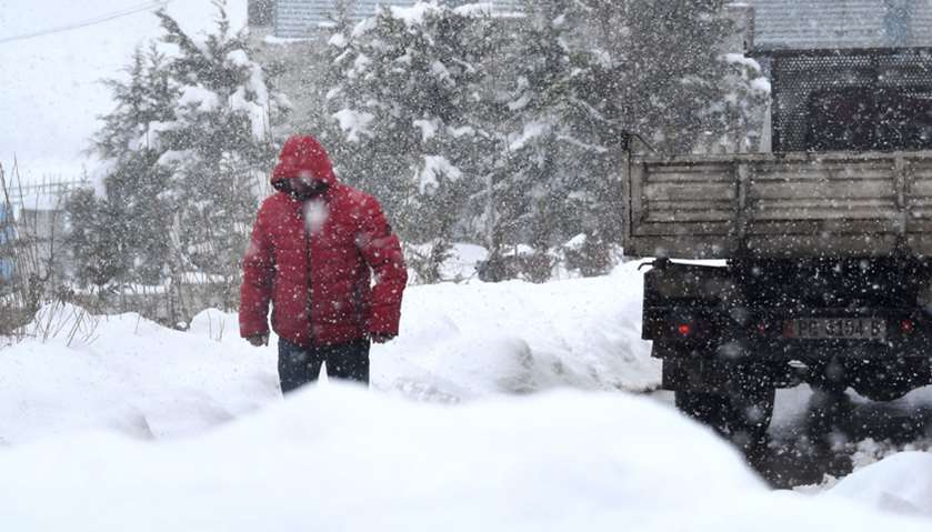 A man walks under heavy snow in Pogradec, southeastern Albania