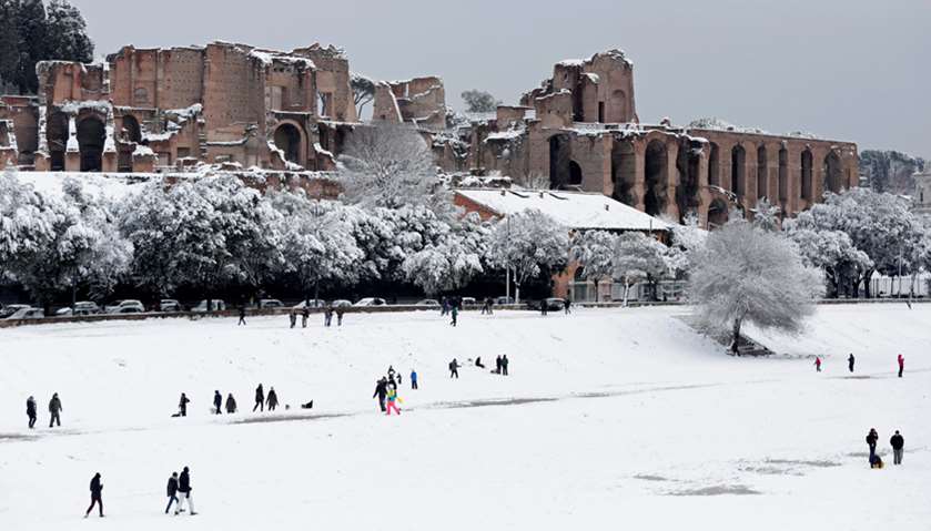 People walk during a heavy snowfall at the Circus Maximus in Rome, Italy