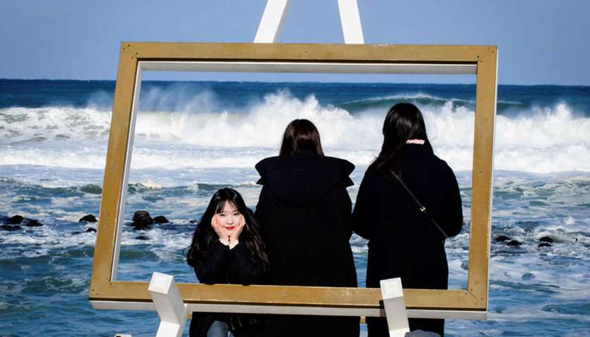 Three girls pose for a selfie at Gyeongpo beach in Gangneung, ahead of the Pyeongchang 2018 Winter O